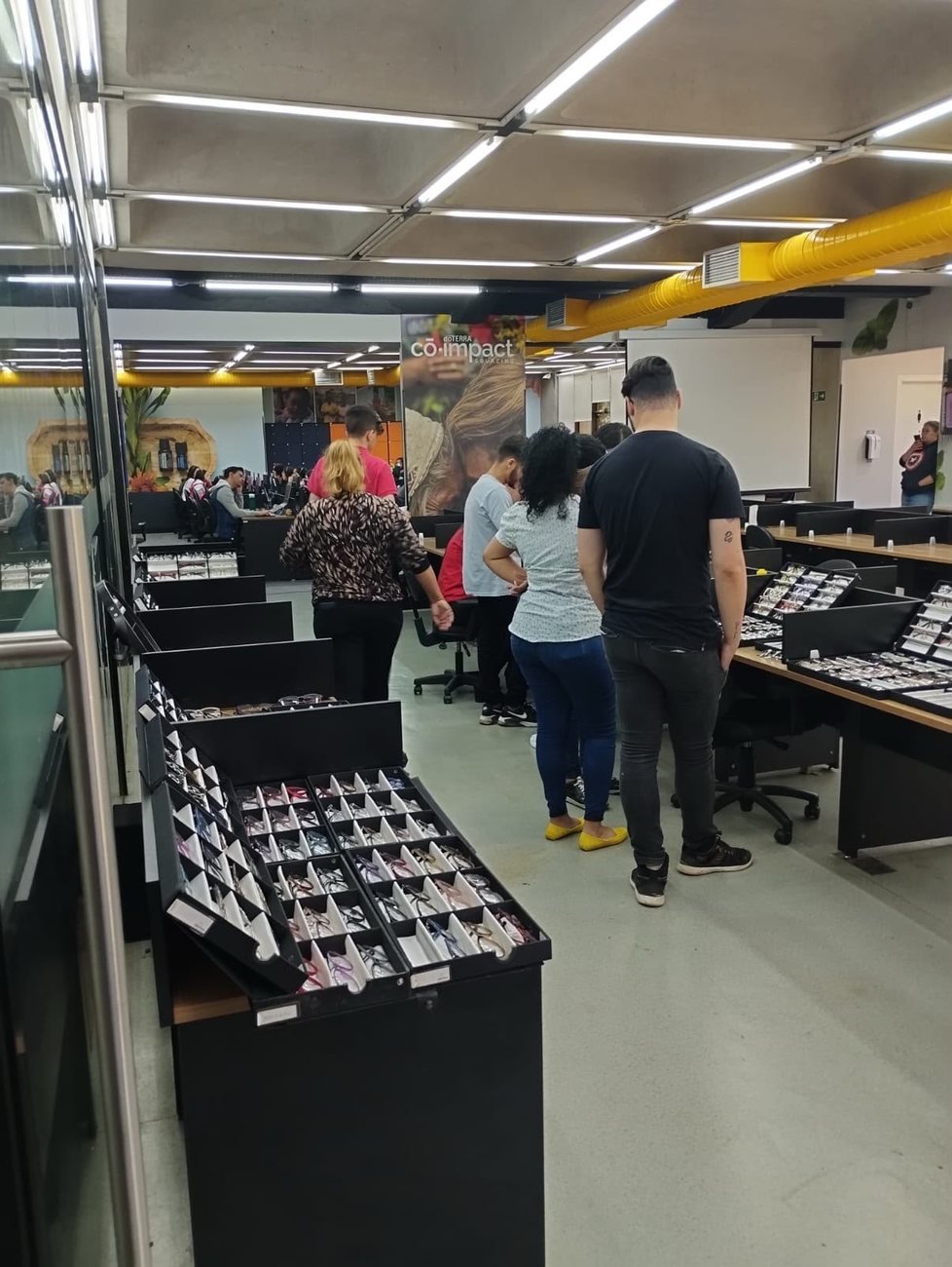 Colaboradores da dōTERRA experimentando armações no showroom exclusivo